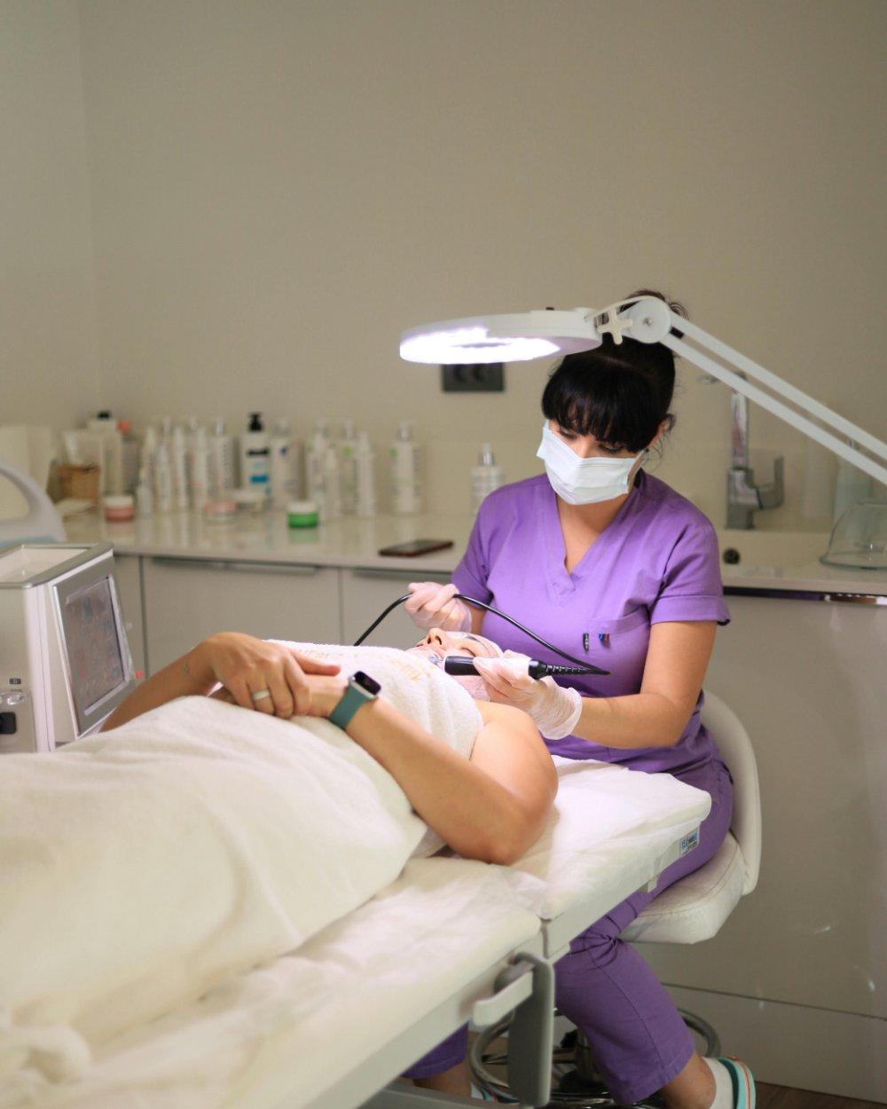 Esteticista realizando procedimento facial em cliente