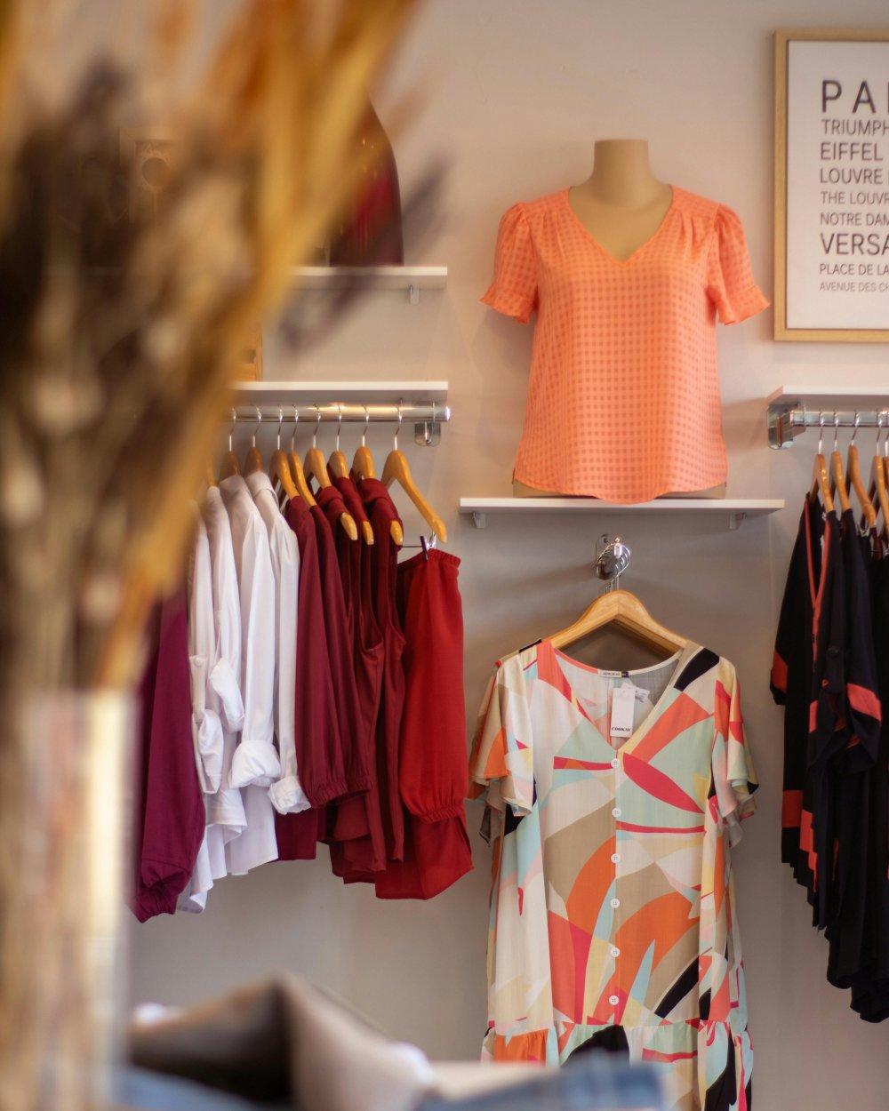 Arara com peças de roupa e vitrine de loja de vestuário